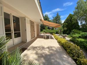un patio con tavolo e sedie in una casa di Villa au calme 500 m plages et port santa lucia a Saint-Raphaël