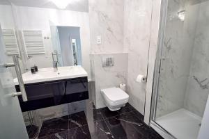 a bathroom with a sink and a toilet and a shower at CRYSTAL Apartament 80m od plaży in Kołobrzeg