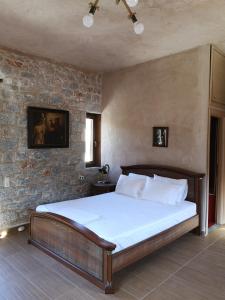 a bed in a room with a brick wall at Παραδοσιακός πύργος in Yerolimin