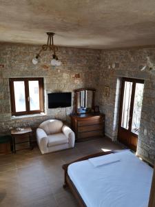 a bedroom with a bed and a tv and a chair at Παραδοσιακός πύργος in Gerolimenas