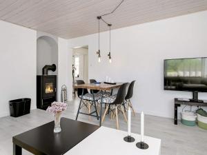 a living room with a table and a fireplace at 5 person holiday home in L s in Læsø