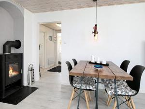 a dining room with a table and a fireplace at 5 person holiday home in L s in Læsø
