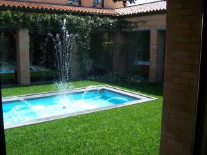 uma piscina com uma fonte no quintal em Villa Cavour em Bottanuco