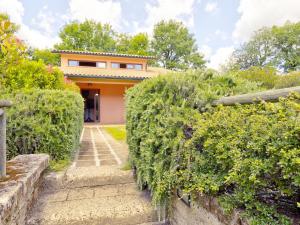 a house with a hedge in front of a building at Pleasing Holiday Home in Sorano with Swimming Pool in Sorano