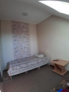 チホレツクにあるГостевой Дом "На Энгельса"のベッドとテーブル付きの小さな部屋