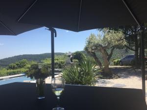 een glas wijn zittend op een tafel onder een paraplu bij Delighful Villa in Berlou with Private Swimming Pool in Berlou