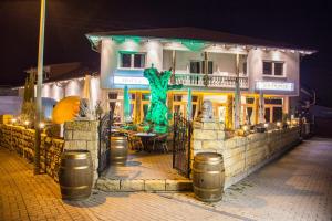 a building with a green statue in front of it at Hotel Restaurant Artemis in Weisenheim am Berg