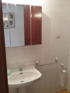 a white bathroom with a sink and a mirror at Ático vacacional in Muros +11 photos