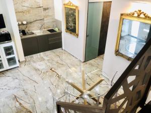 een badkamer met een glazen tafel op een marmeren vloer bij Dimora Umberto Apartment in Catania