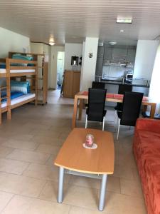 a living room with a couch and a table and a kitchen at Apartment Laura in Wilderswil