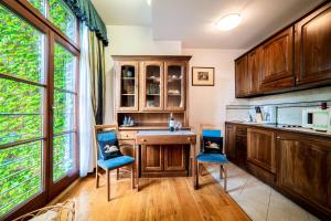 a kitchen with wooden cabinets and blue chairs at Aparthotel Hornigold "W Zielonej Kamienicy" in Katowice