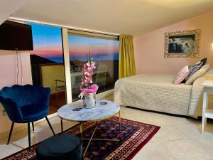 a living room with a bed and a table and a room at Hotel Scilla in Scilla