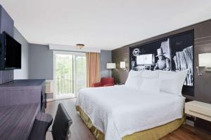 a hotel room with a bed and a television at Super 8 by Wyndham Sturbridge in Sturbridge