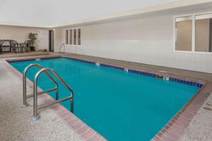 a large pool with blue water in a building at Days Inn by Wyndham near Kansas Speedway in Kansas City