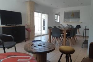 a living room with a table and chairs and a television at Maison Aigues-Mortes 8 couchages in Aigues-Mortes