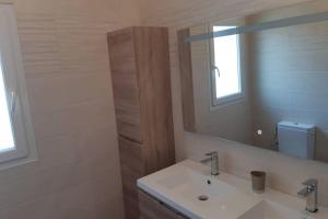 a bathroom with a sink and a mirror at Maison Aigues-Mortes 8 couchages in Aigues-Mortes +4 photos