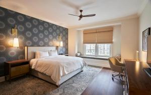 a bedroom with a bed and a desk and a window at The Inn at Meadowbrook in Prairie Village