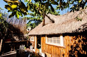 ein Haus mit einem Strohdach und einem Zaun in der Unterkunft Chill Inn Hostel in Tulum