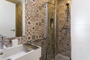 y baño con lavabo y ducha. en Suites Amália Guesthouse near Rossio Square, en Lisboa