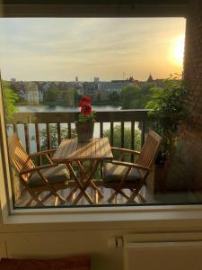 a patio table with a vase of flowers on a balcony at ApartmentInCopenhagen Apartment 1442 in Copenhagen