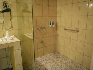 um chuveiro com uma porta de vidro na casa de banho em Sueños del Bosque Lodge em San Gerardo de Dota