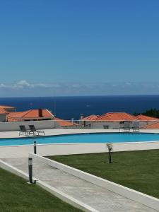 a large swimming pool with a view of the ocean at NazOndas Ap in Nazaré