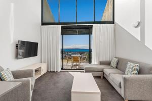 a living room with a couch and a tv at Landmark Resort in Nelson Bay