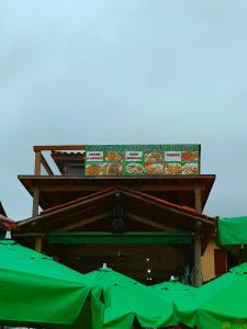 a building with food on top of it with green umbrellas at Pousada Guaruça in Trindade