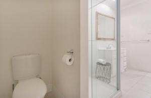 
a bathroom with a toilet, sink, and shower stall at Siroque Fremantle in Fremantle
