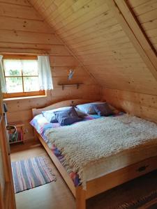 1 dormitorio con 1 cama en una cabaña de madera en Robakówka, en Ochotnica Dolna