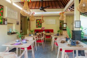 ein Restaurant mit Holztischen und roten Stühlen in der Unterkunft Ratna Villa in Ubud