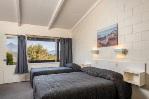 Ένα ή περισσότερα κρεβάτια σε δωμάτιο στο Queenstown Motel Apartments