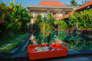 einen Tisch mit einem Teller Essen in einem Korb neben einem Haus in der Unterkunft Ratna Villa 4 in Ubud