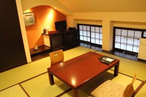 a living room with a wooden table and chairs at Maruyama Onsen Kojyokan in Minami Uonuma