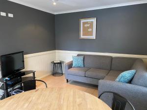 a living room with a couch and a table at NRMA Atherton Tablelands Holiday Park in Atherton