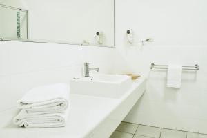 a white sink sitting next to a white towel rack at The Coast Motel in Yeppoon