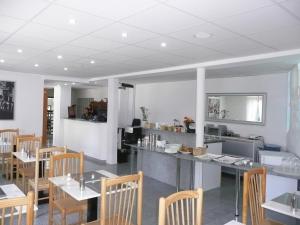 a restaurant with white walls and wooden tables and chairs at City Hotel in Ludwigsburg