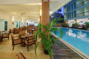 un ristorante con piscina e tavoli e sedie di Smiling Hotel a Siem Reap