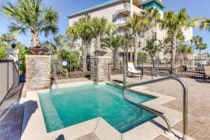 a swimming pool in front of a house with palm trees at Alerio Condos in Destin