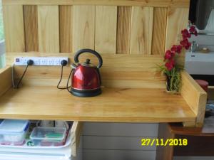 uma chaleira de chá em cima de uma mesa de madeira em Room with a view em Waipu