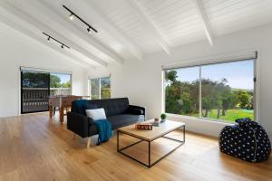 a living room with a couch and a table at 1 Oak - Rye Back Beach Accommodation in Saint Andrews Beach