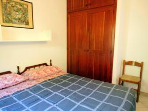 1 dormitorio con 1 cama y armario de madera en Villetta Best Vacation Ever, Costa Rei, en Costa Rei