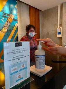uma mulher com uma máscara facial ao lado de um frasco de medicação em Kama Hotel em Medan