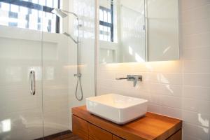 WaimaramaLightning Ridge Views - Waimarama Holiday Home的白色的浴室设有水槽和淋浴。