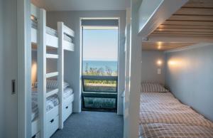 WaimaramaLightning Ridge Views - Waimarama Holiday Home的一间带双层床的卧室,享有海景