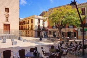 an empty courtyard with tables and chairs and a tree at Apartamento Cop City Centre by costablancarent in Denia