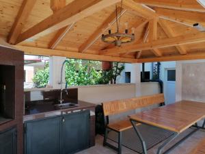 a kitchen with a wooden ceiling and a table at Apartmani Karla in Zablaće