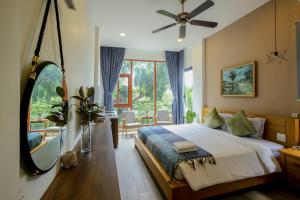 a bedroom with a bed and a large window at Magnolia's Can Tho in Can Tho