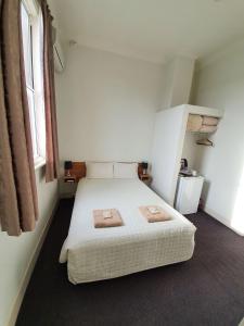 a bedroom with a bed with two towels on it at Empire Hotel Goulburn in Goulburn