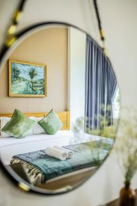 a mirror reflection of a bed in a bedroom at Magnolia's Can Tho in Can Tho